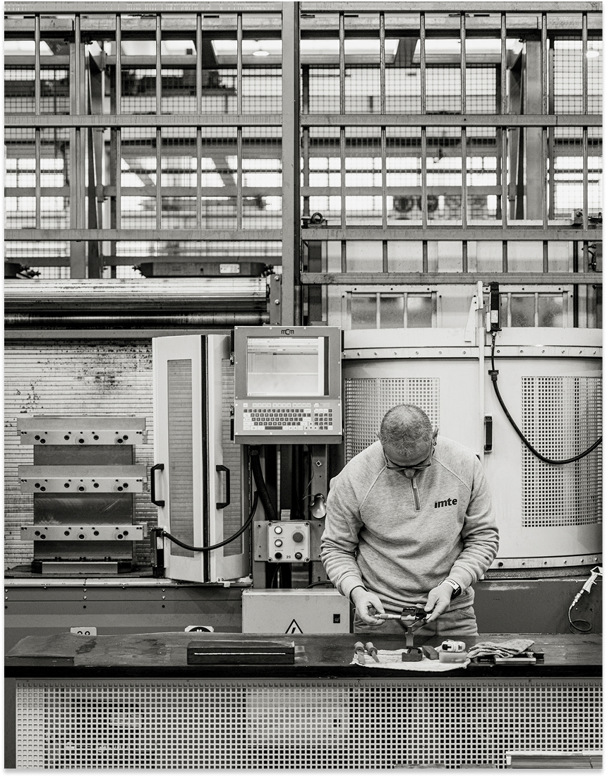 IMTE technician working with press brake tooling components in a modern workshop, highlighting precision engineering and industrial expertise.